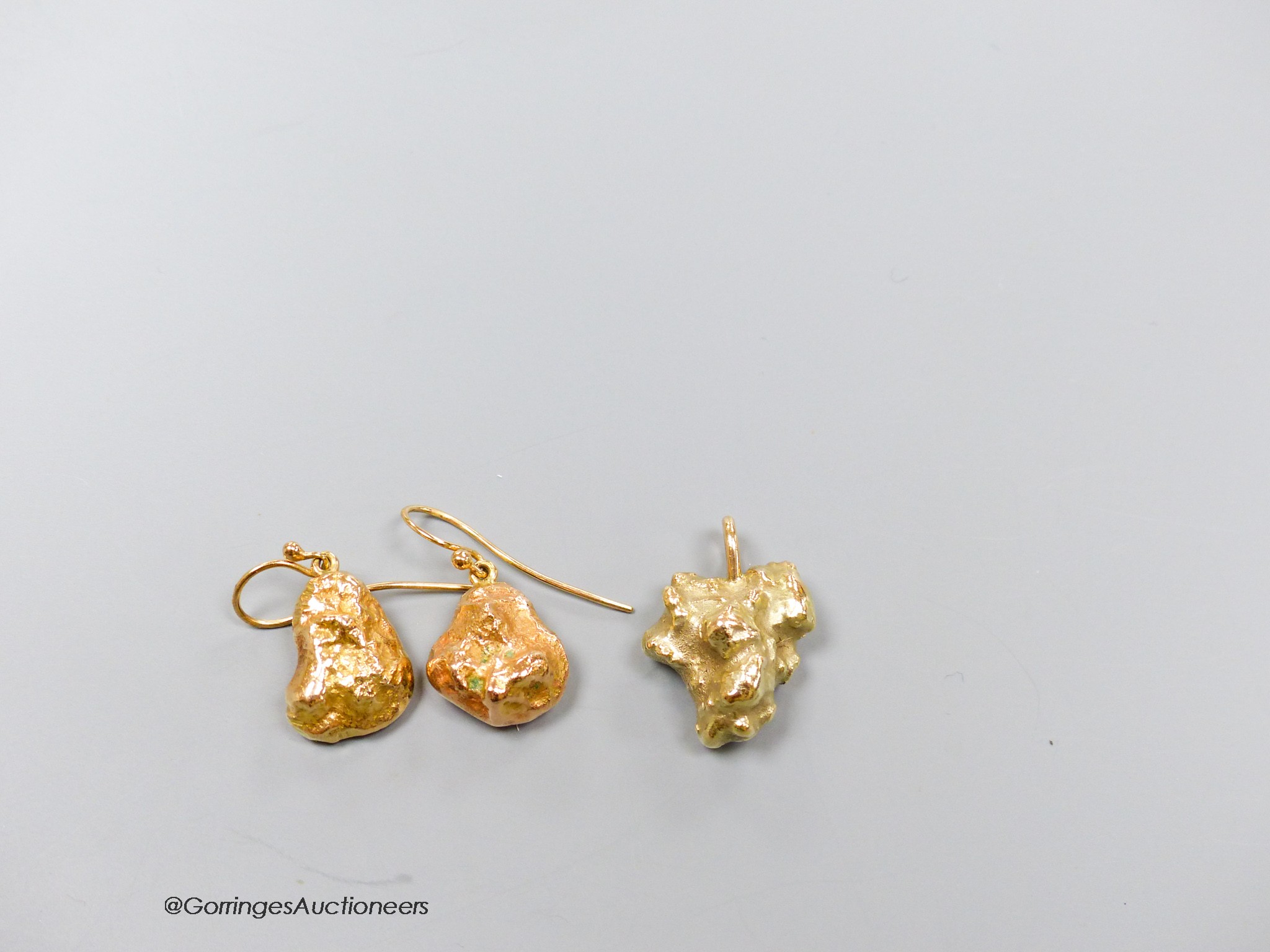 A modern 9ct gold nugget pendant and a pair of similar 9ct earrings, gross 26.1 grams.